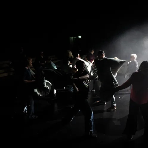 Menschen unterschiedlichen Alters, von jung bis älter, alle Hautfarben und Geschlechter machen eine Kissenschlacht.