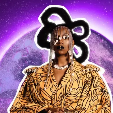 Person mit geflochtenen Haaren und Schmuck trägt ein gelb-braunes, gemustertes Outfit und steht vor einem violetten Hintergrund mit einem leuchtenden Kreis.
