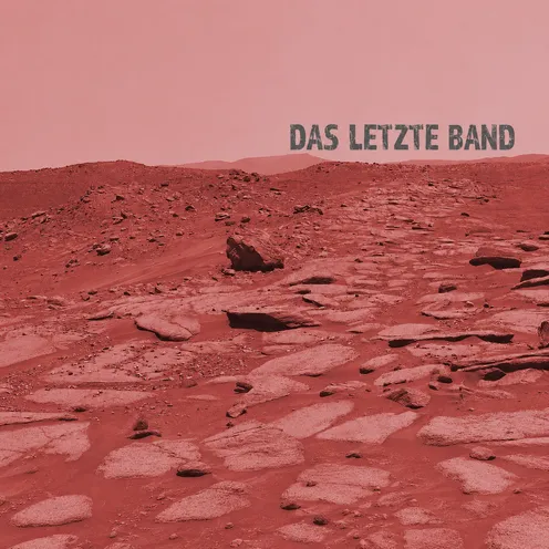 Eine karge, rötlich schimmernde Landschaft erinnert an die Oberfläche des Mars. Zerklüftete Felsen und staubige Ebenen reichen bis zum Horizont. Über der stillen Szenerie steht der Titel „Das letzte Band“ und vermittelt eine Atmosphäre von Einsamkeit und Vergänglichkeit.